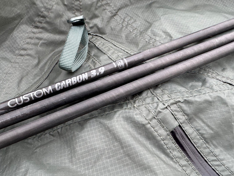 Two fishing rods labeled 'Custom Carbon' on a gray surface