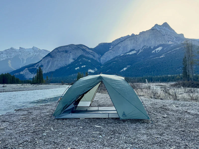 Camping tent in a mountainous landscape with a river