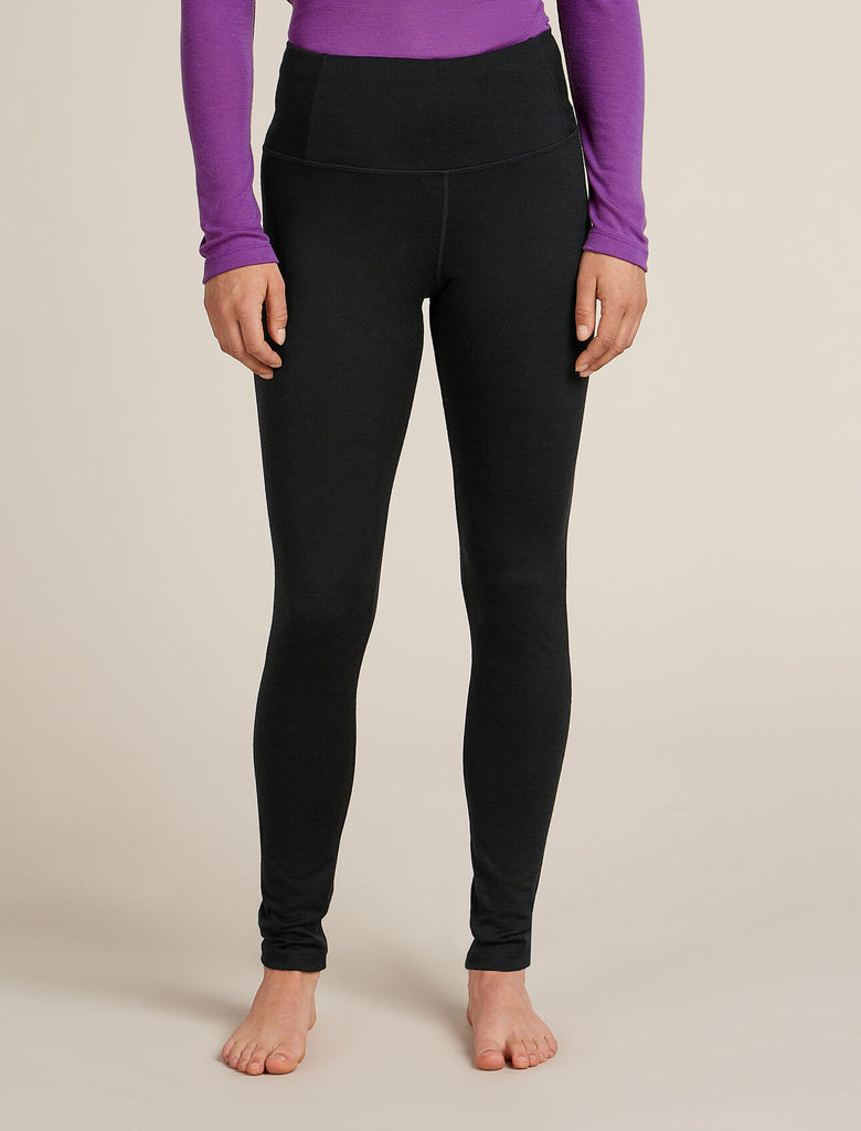 Person wearing black leggings and a purple top on a beige background