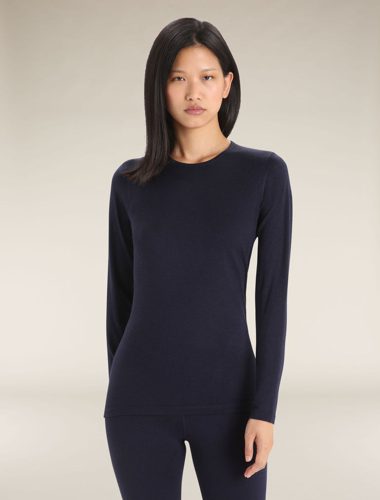 Woman wearing a navy long-sleeve top against a neutral background