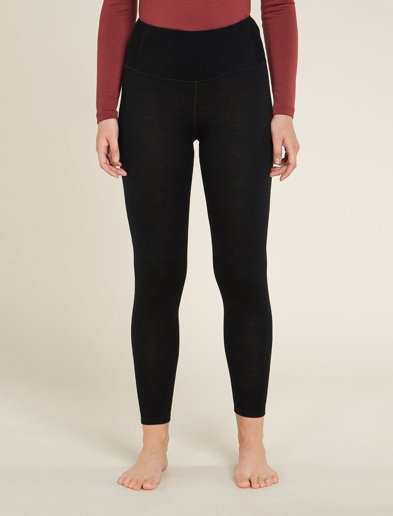 Person wearing black leggings on a beige background