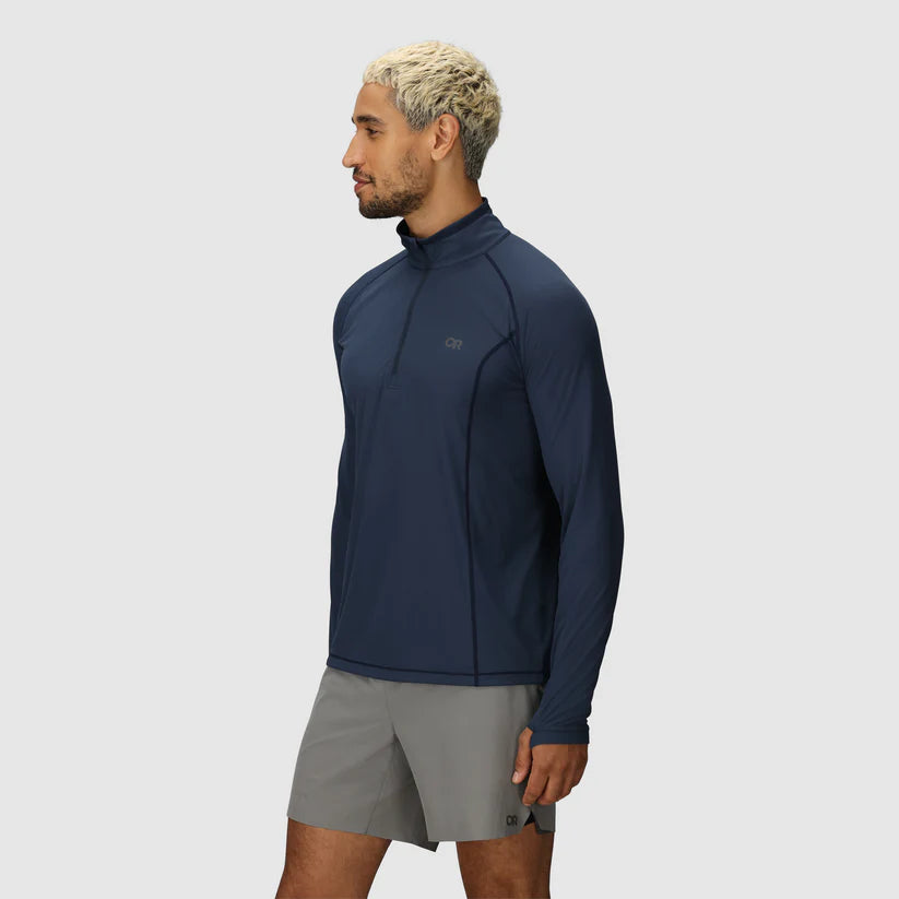 Man wearing a navy blue athletic jacket and gray shorts on a light gray background