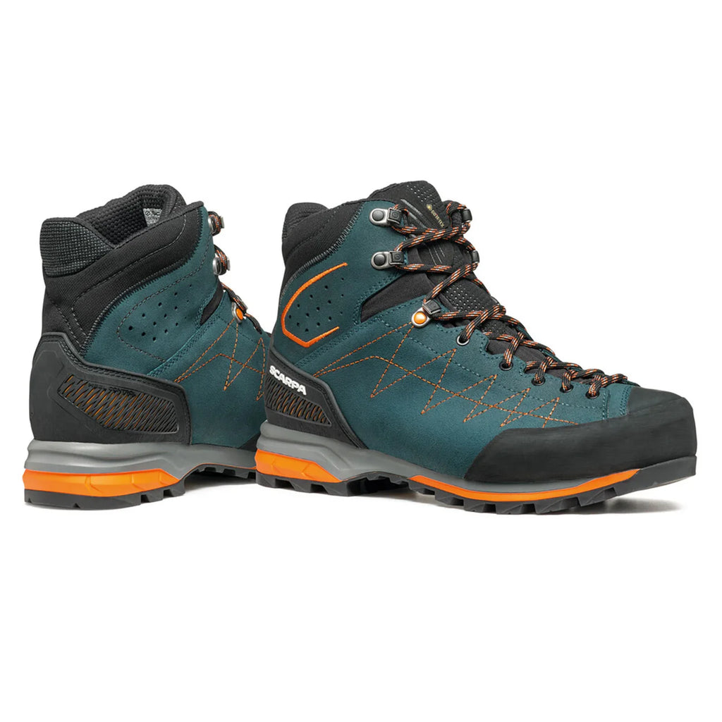 Pair of teal and black hiking boots with orange accents on a white background
