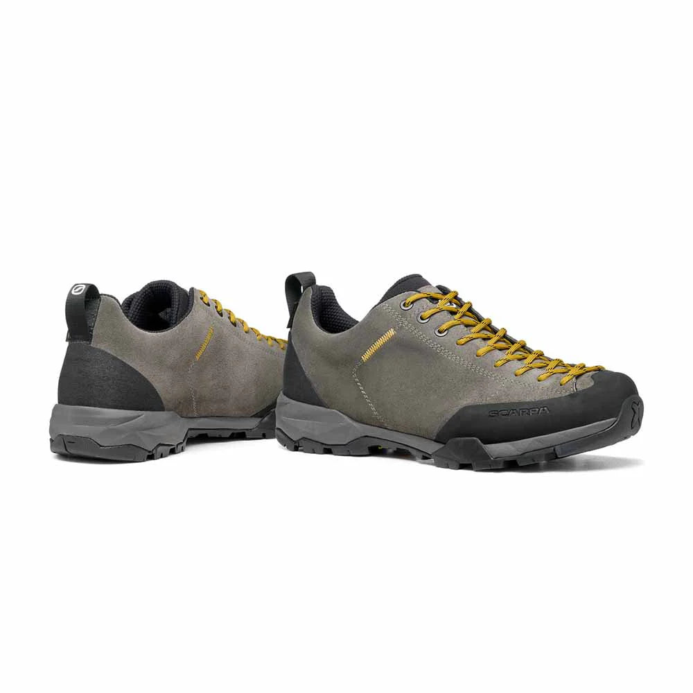 Pair of gray and black outdoor shoes with yellow laces on a white background