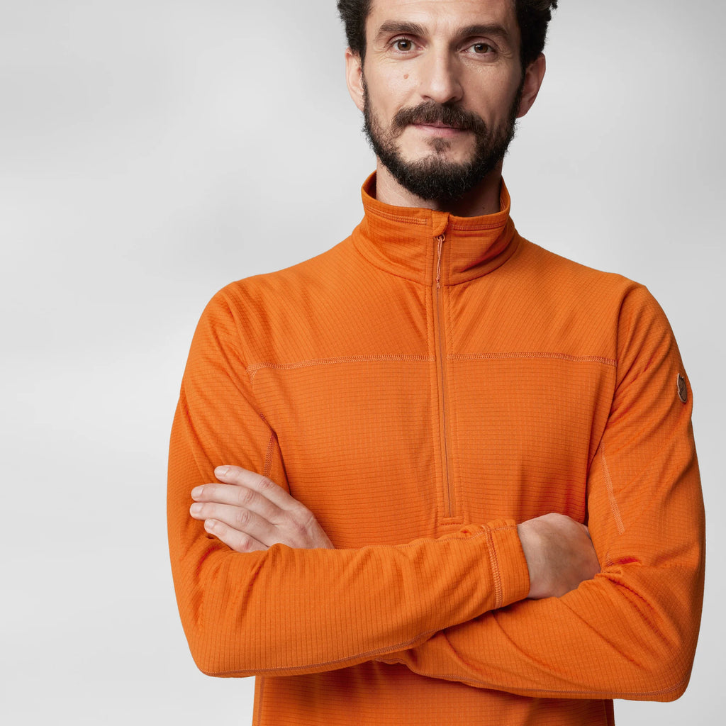 Man wearing an orange fleece with a neutral background