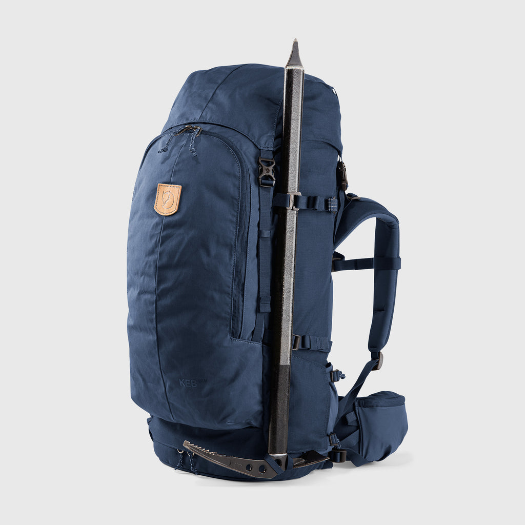 Navy blue backpack with a trekking pole attached on a light gray background