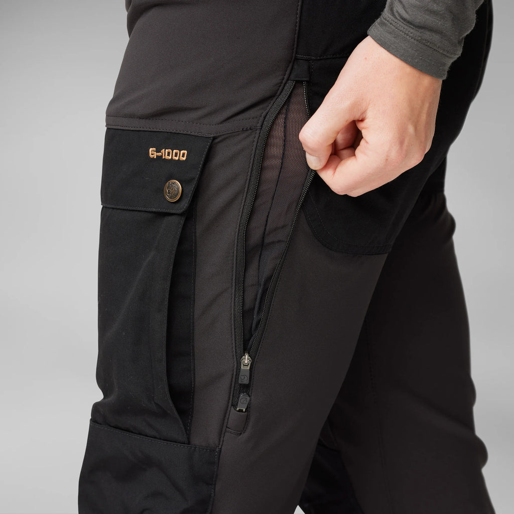 Close-up of black pants with a pocket label on a gray background