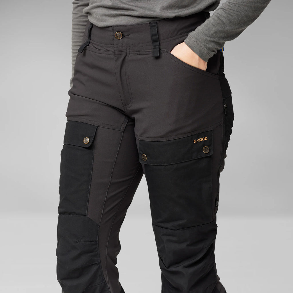 Black cargo pants with multiple pockets on a gray background